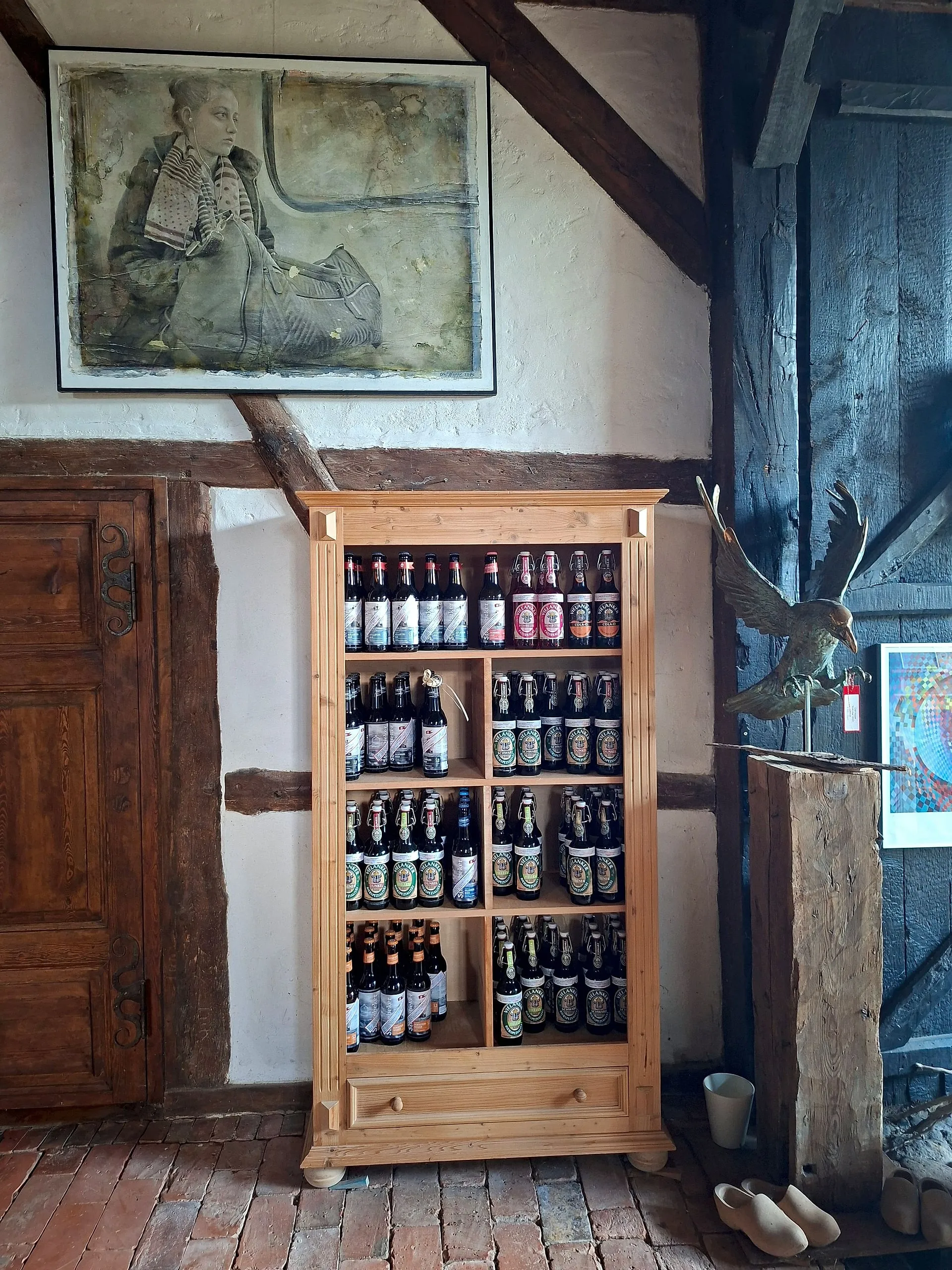 Holzschrank voller Bierflaschen, darunter Editionen mit Kunst-Etiketten