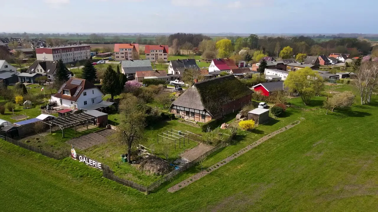 Luftaufnahme des reetgedeckten Hofes mit Galerie und Stellplatz nahe der offenen Landschaft